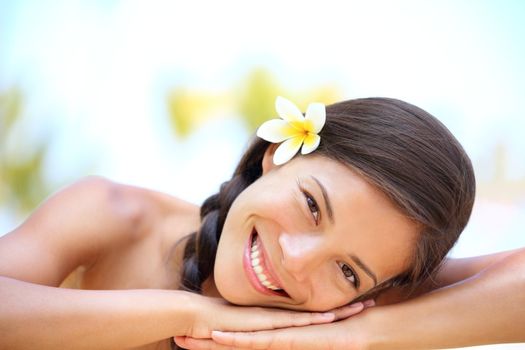 Woman natural beauty. Beautiful smiling girl outdoor portrait at massage spa. Serene happy ethnic woman relaxing looking joyful at camera. Mixed race Asian / Caucasian female model outdoors.