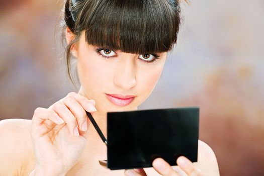 pretty woman applying make up with brush