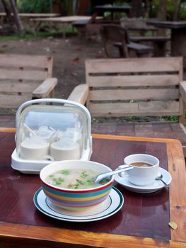 Thai style breakfast soft boiled rice mixed with ground pork, seasoning unit and coffee