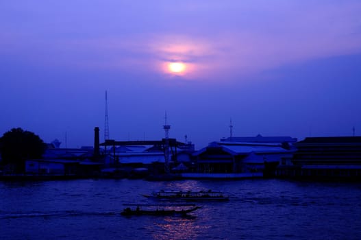 Long tail boat in Chaopraya river at sunset