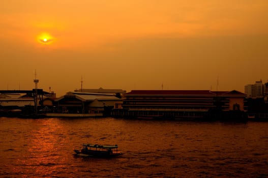 Long tail boat in Chaopraya river at sunset