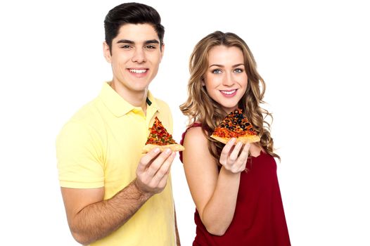 Boy and girl each holding slice of yummy pizza.