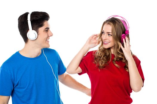 Lovely young couple with headphones on tuned into musical world.