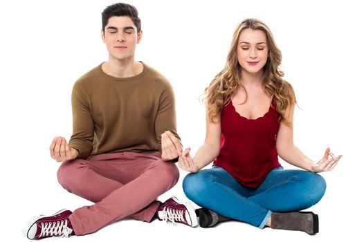 Young man and woman on white background meditating peacefully.