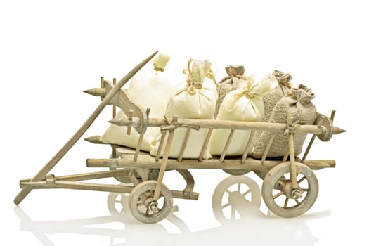 Old fashioned wooden handcart with bags of straw and potatoes