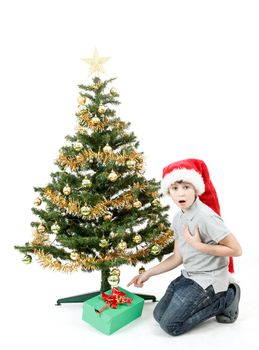 surprised boy in santa hat with christmas present on white background