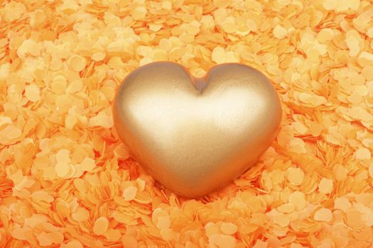 Heart from gold in orange confetti