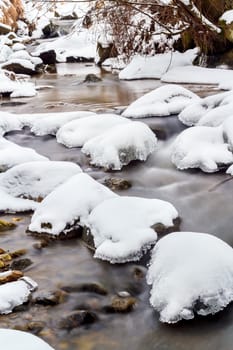 Falls on the small mountain river in a wood shooted in winter