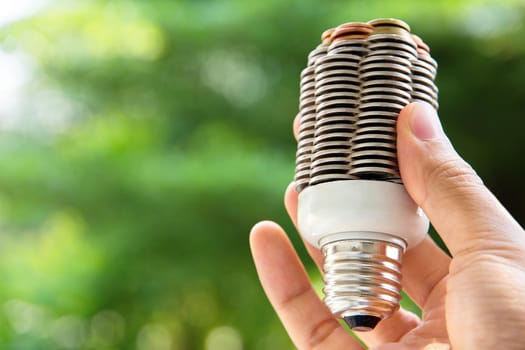 hand holding coin light bulb,energy concept