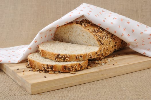 Slices of whole grain bread with cereals on a wooden board