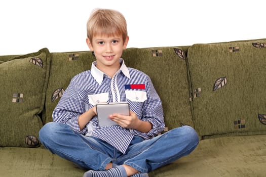 happy boy sitting on bed and play with tablet pc