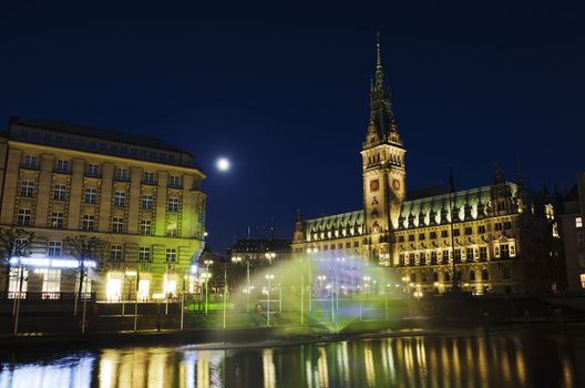 A colorful lighted fountain on the Alster in front of the town hall of Hamburg.