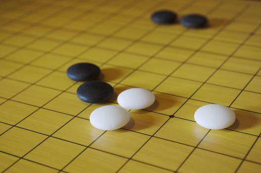 Picture taken during a game of go. Go is an ancient traditional Asian board game. Shallow depth of field.