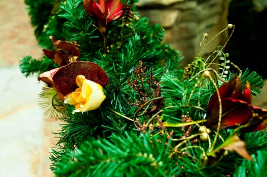 Holiday garland with burgundy and yellow flowers.