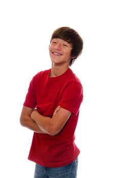 Happy teen in red shirt and jeans smiling with arms crossed.