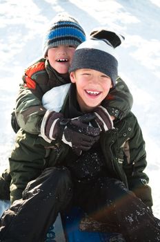 Two young boys smiling in the snow.