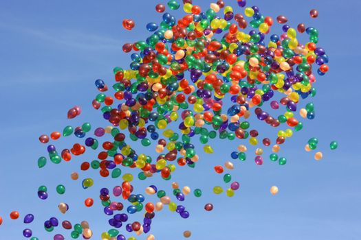 Many colored balloons flying in the blue sky.