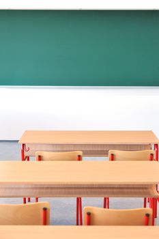 A classroom shot of desks with clear blackboard