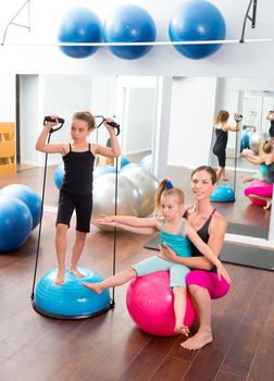 Aerobics woman personal trainer of children girl with stability ball