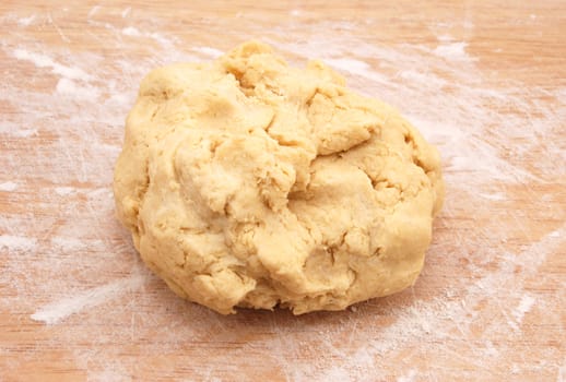 Fresh ball of pastry ready to be rolled out on a floured wooden board