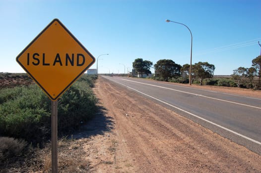 Yellow road sign island in outback of Australia