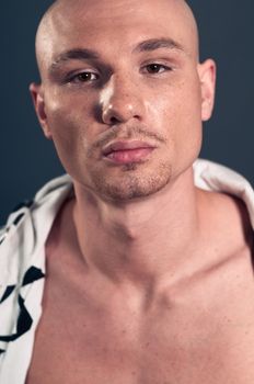 Studio portrait of shirtless muscled bald man