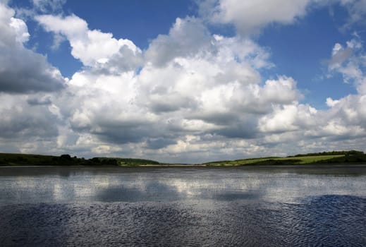 Low heavy clouds over the river. Summer landscape