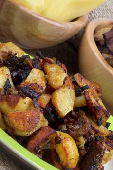 Roasted Potato with Mushrooms and Onion on Two Wood Bowls with Raw Potato, Onion and Slices of Mushrooms background