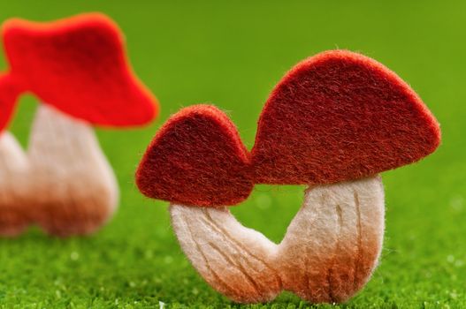 Artificial small mushrooms on artificial green grass
