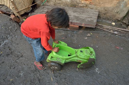 child playing in the mud in New Delhi