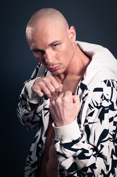 Portrait of naked athletic man posing over gray background