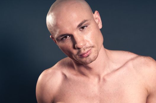 Studio portrait of shirtless muscled bald man