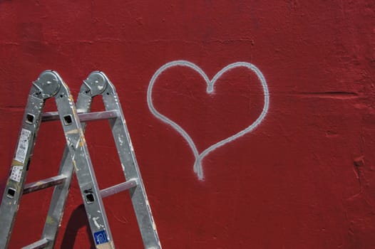 Heart graffiti on a red wall with ladder