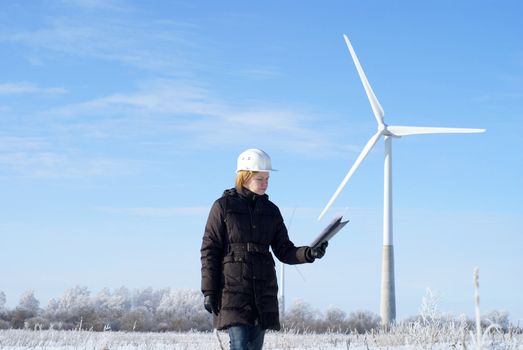 engineer or architect with white safety hat and wind turbines on background