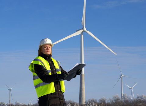 engineer or architect with white safety hat and wind turbines on background