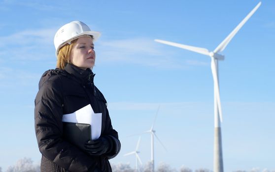 engineer or architect with white safety hat and wind turbines on background