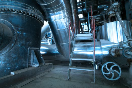 Equipment, cables and piping as found inside of  industrial power plant