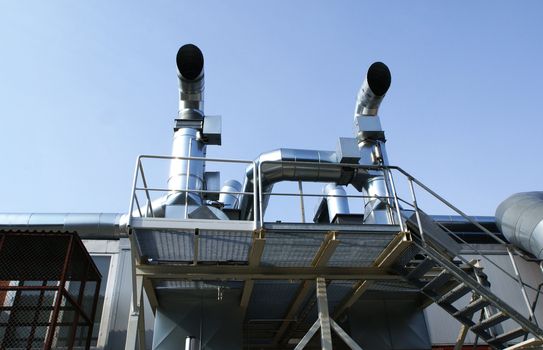 Ventilation pipes of an air condition against blue sky
