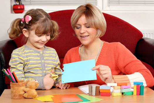 daughter and mother cutting paper and play with plasticine