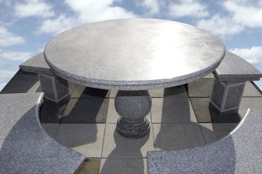 large marble table and chairs against a bright cloudy background