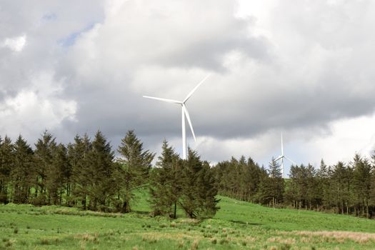 windmills on the hills of Glenough in county Tipperary Ireland with trees and fields in foreground