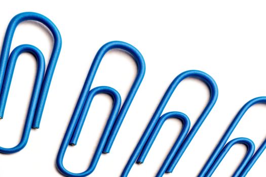 Perspective view of blue paperclips on white background
