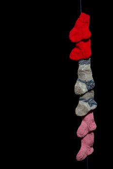 Three pairs of baby socks in front of a black background