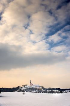 Evening mood Monastery Andechs in Bavaria in Winter with snow and clouds