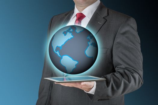 Well dressed business man is holding a tablet computer that is showing an illustration of the earth. Background is blue / black.