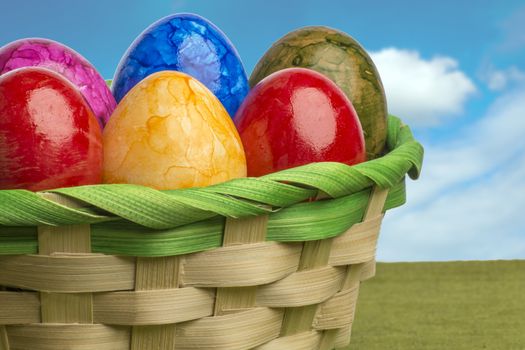 Colored easter egg basket with blue sky and white clouds