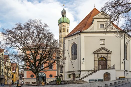 Church with houses, trees, street and clouds in the small town Dachau in Germany