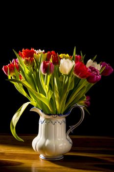 Bouquet of Flowers in Vase on a wooden table and black background