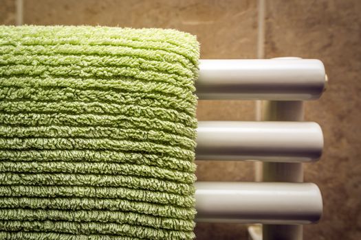 Green towel on a radiator in a bathroom