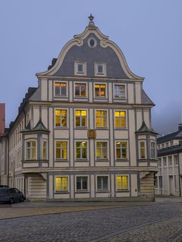 Old house in the evening with lit rooms